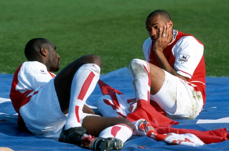 15 May 2004 - Premiership Football - Arsenal v Leicester City - Sol Campbell and Thierry Henry of Arsenal sit on a large Premiership flag and talk ...