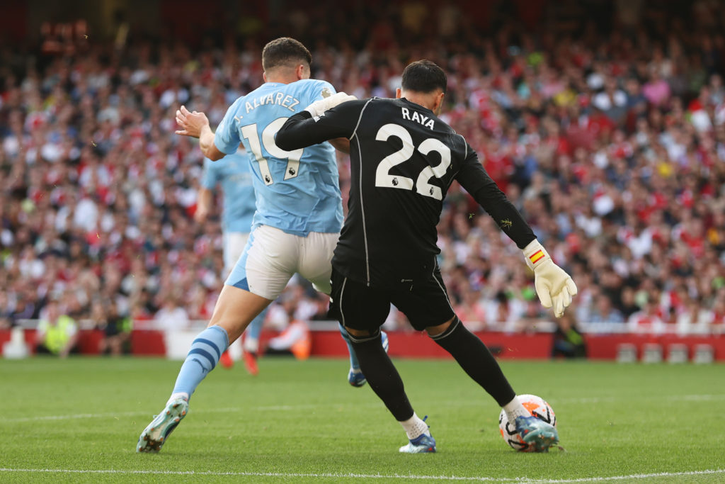 Manchester City forward Julian Alvarez challenges Arsenal goalkeeper David Raya in Premier League