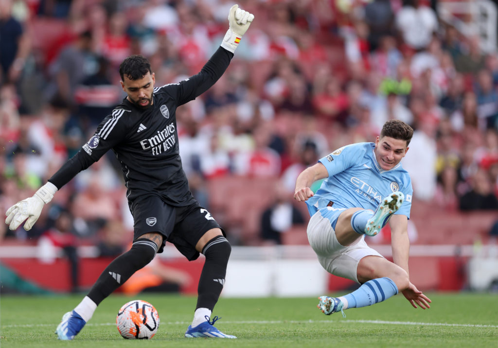 Manchester City forward Julian Alvarez challenges Arsenal goalkeeper David Raya in Premier League