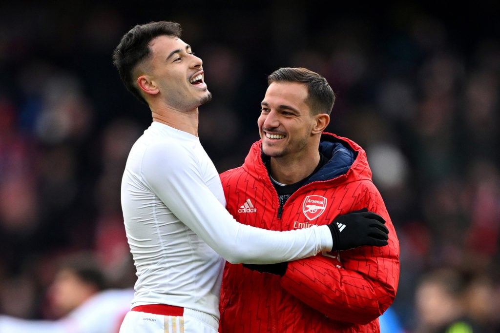 Gabriel Martinelli and Cedric Soares embracing each other and laughing after a game between Arsenal and Crystal Palace in the Premier League