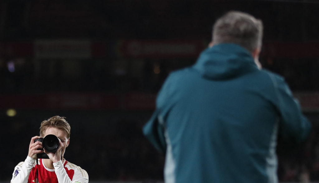 Arsenal captain Martin Odegaard celebrates with club photographer vs Liverpool