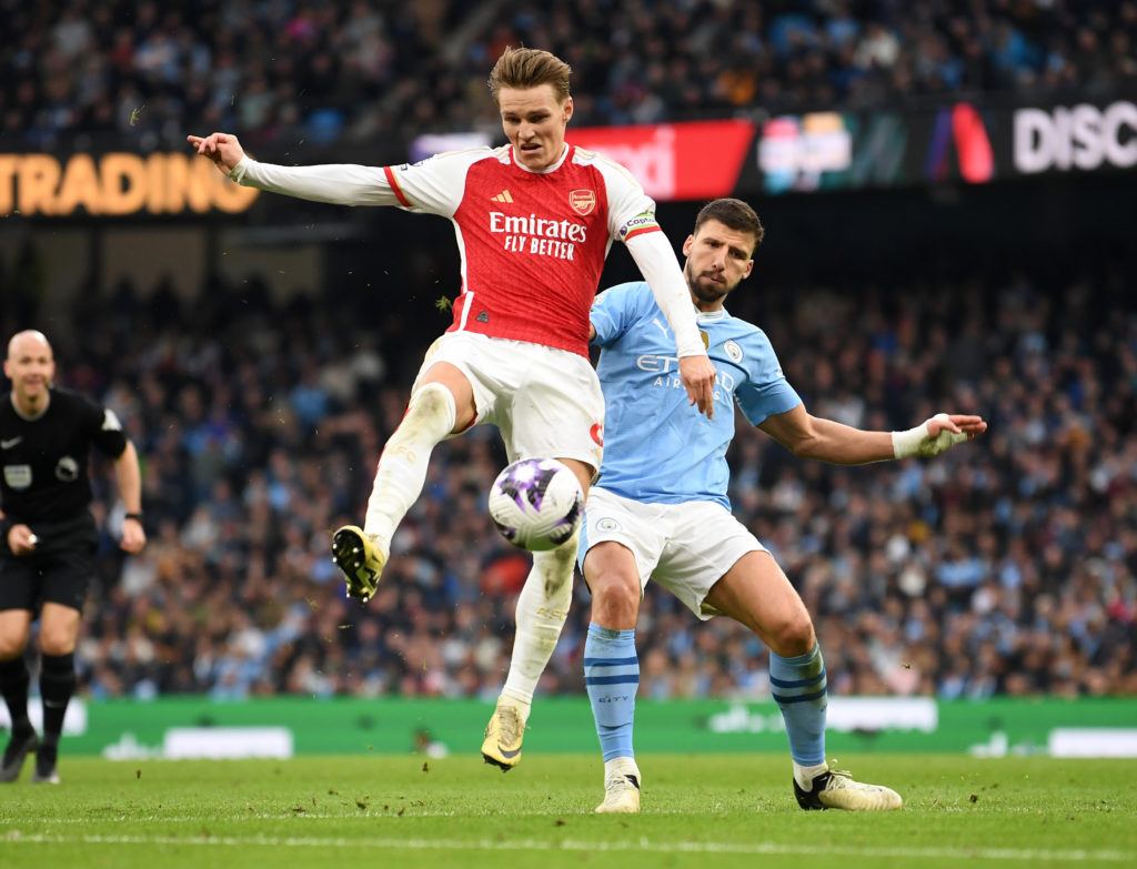 Martin Odegaard battles with Ruben Dias during Manchester City v Arsenal FC in the Premier League clash.