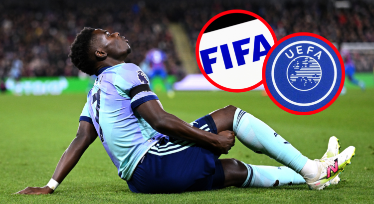 Bukayo Saka reacts to injury surrounded by pictures of the FIFA and UEFA logos.
