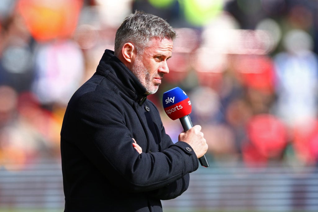 Jamie Carragher holding a mic while working as a pundit