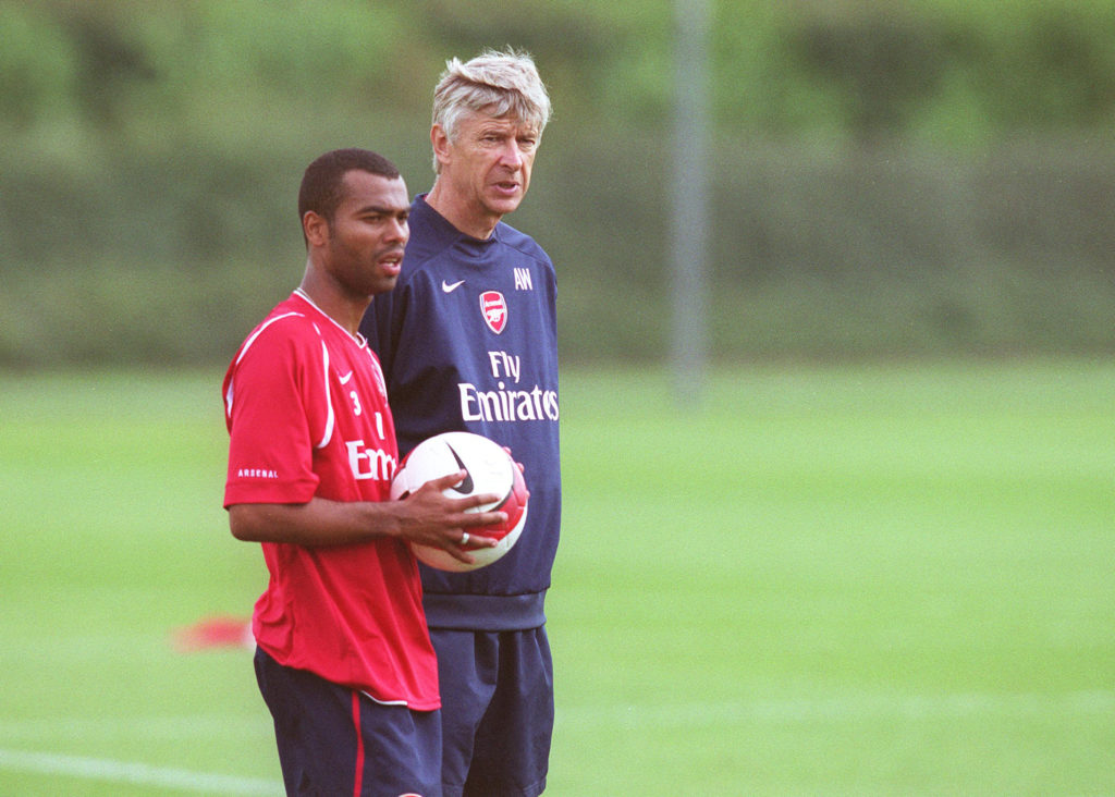Ashley Cole and Arsene Wenger talk to each other during an Arsenal training session.