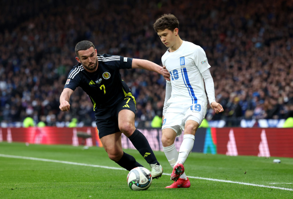 Konstantinos Karetsas battles for possession with John McGinn during Scotland vs Greece.