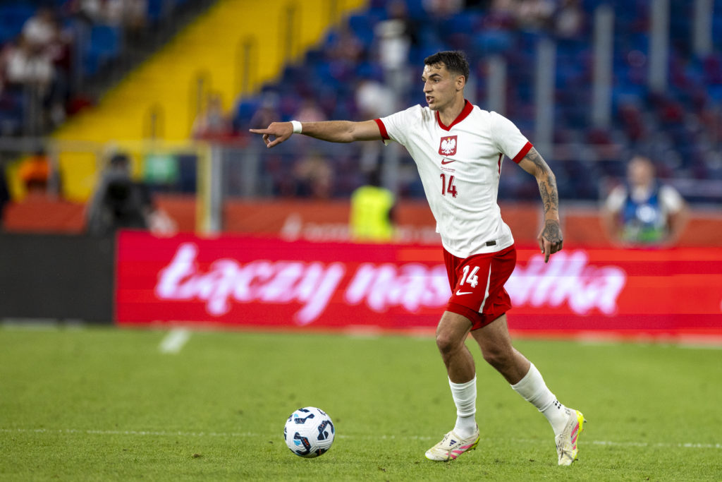Jakub Kiwior strides forward with the ball during Poland's game against Moldova.