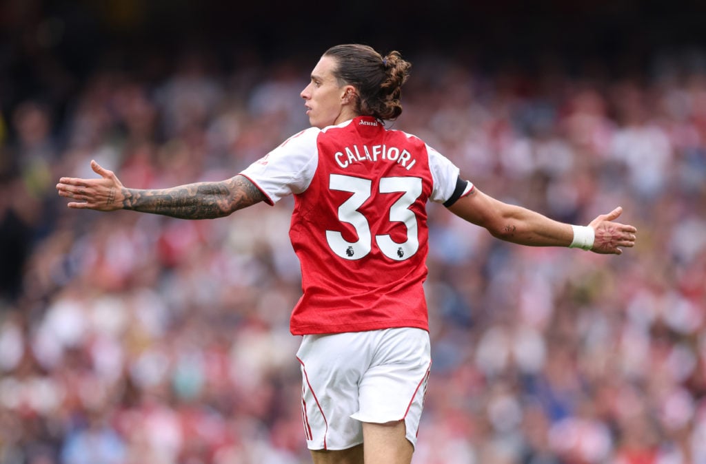Riccardo Calafiori running with his arms out wide during an Arsenal game