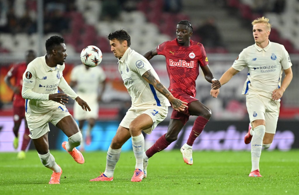 Jakub Kiwior of FC Porto looks to control the ball whilst under pressure from Moussa Yeo of Red Bull Salzburg.