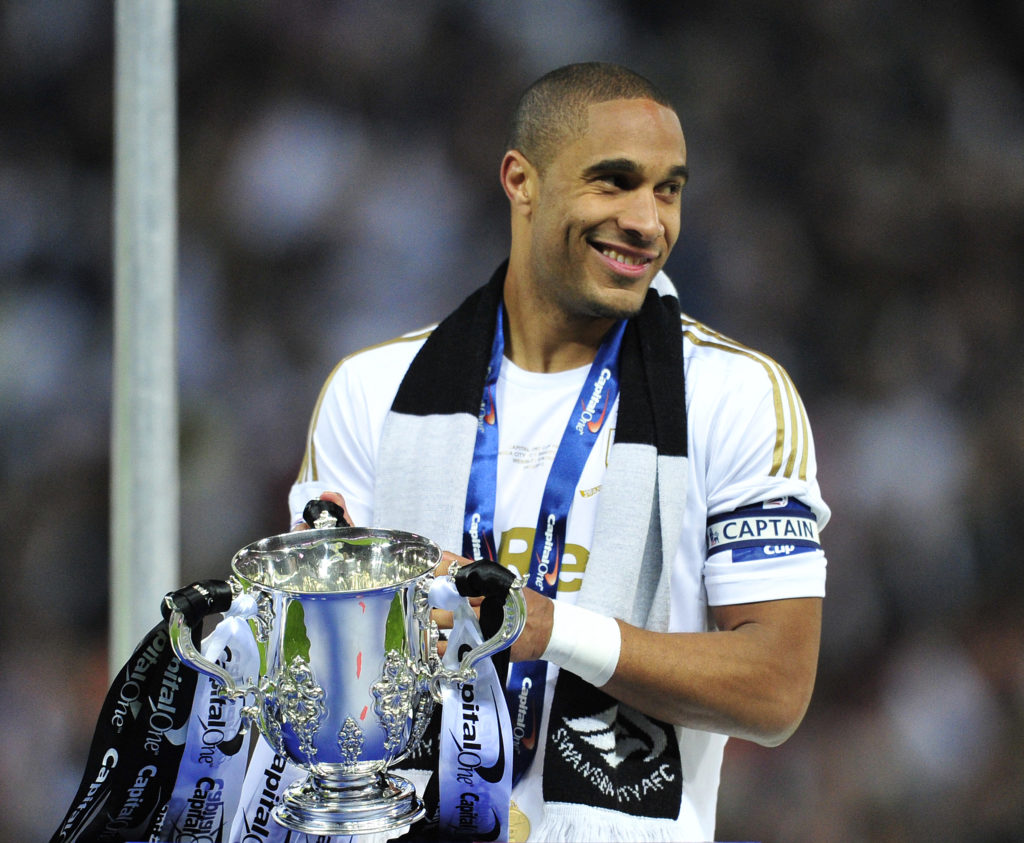 Swansea City's English-born Welsh defender Ashley Williams celebrates with the trophy after the League Cup final football match between Bradford City and Swansea City.