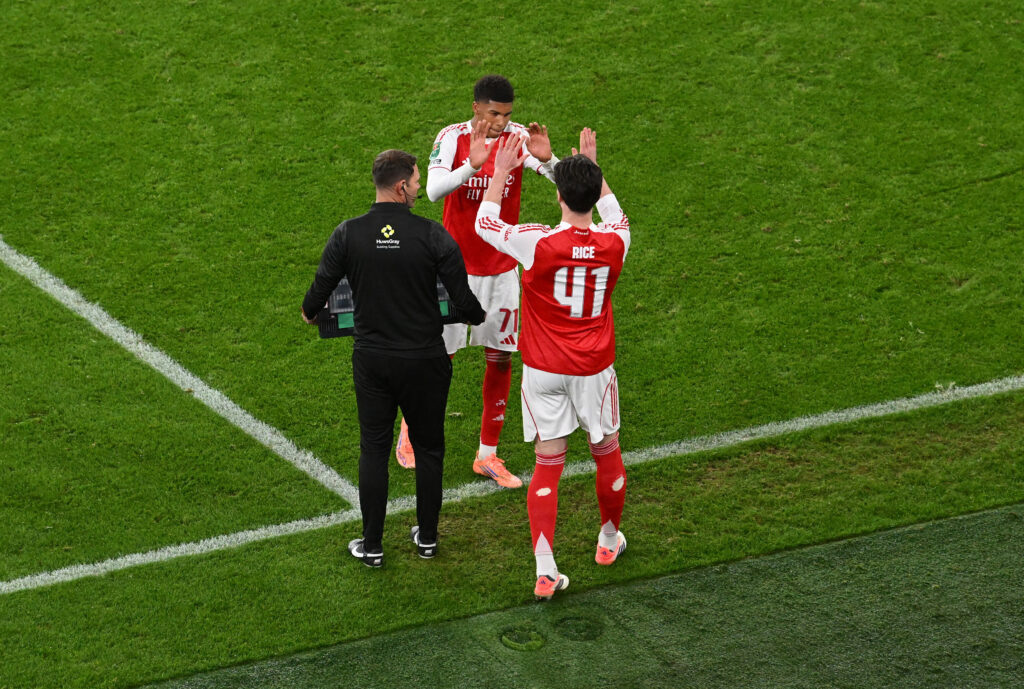 Andre Harriman-Annous shakes hands with Declan Rice during a substitution in an Arsenal game