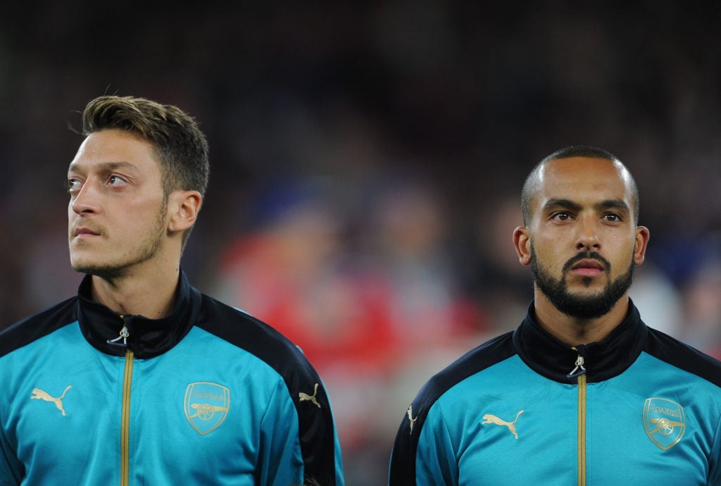 Mesut Ozil and Theo Walcott looking on before an Arsenal game
