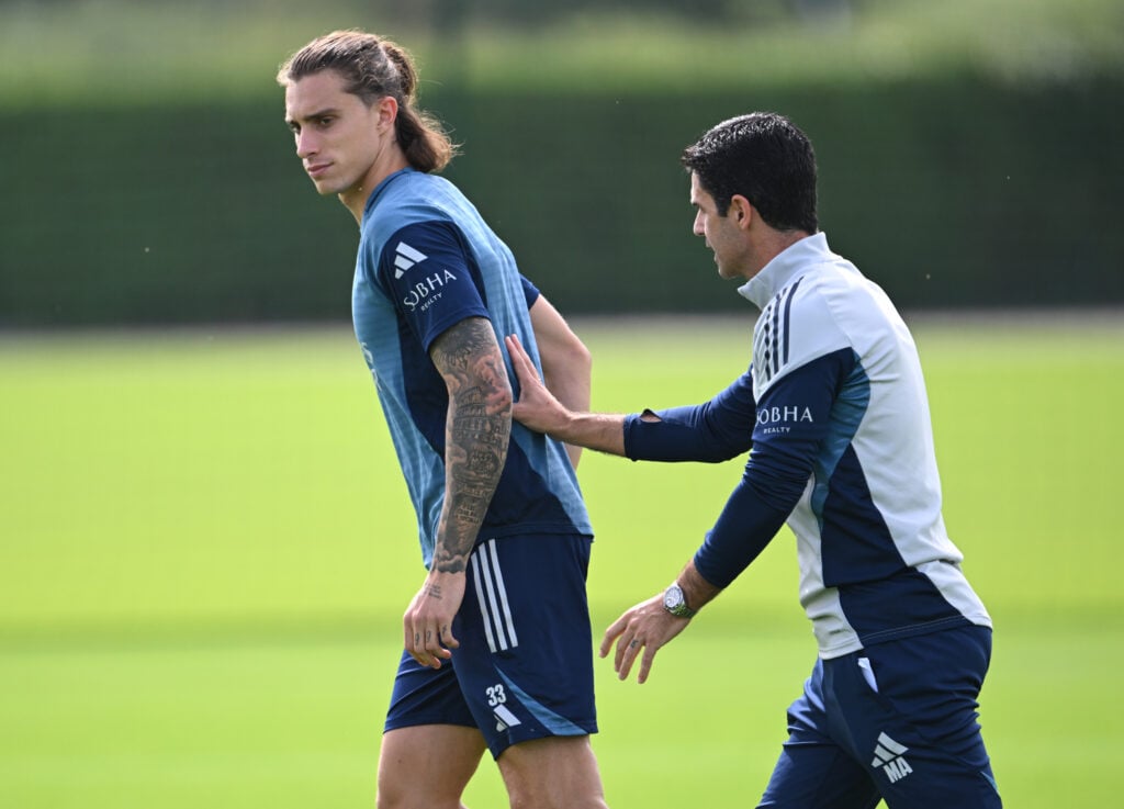 Mikel Arteta speaks with Riccardo Calafiori during an Arsenal training session
