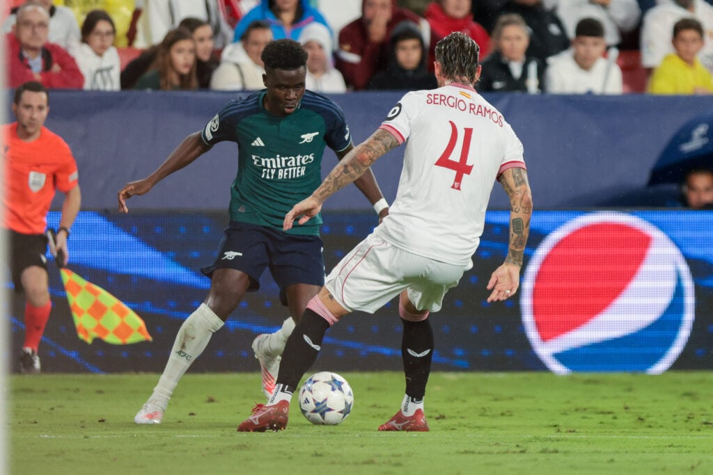 Bukayo Saka of Arsenal FC and Sergio Ramos of Sevilla FC battle for the ball during the UEFA Champions League match between Sevilla and Arsenal.