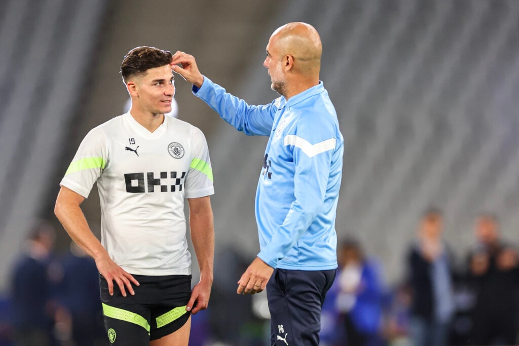 Pep Guardiola speaking to Julian Alvarez during a Manchester City training session