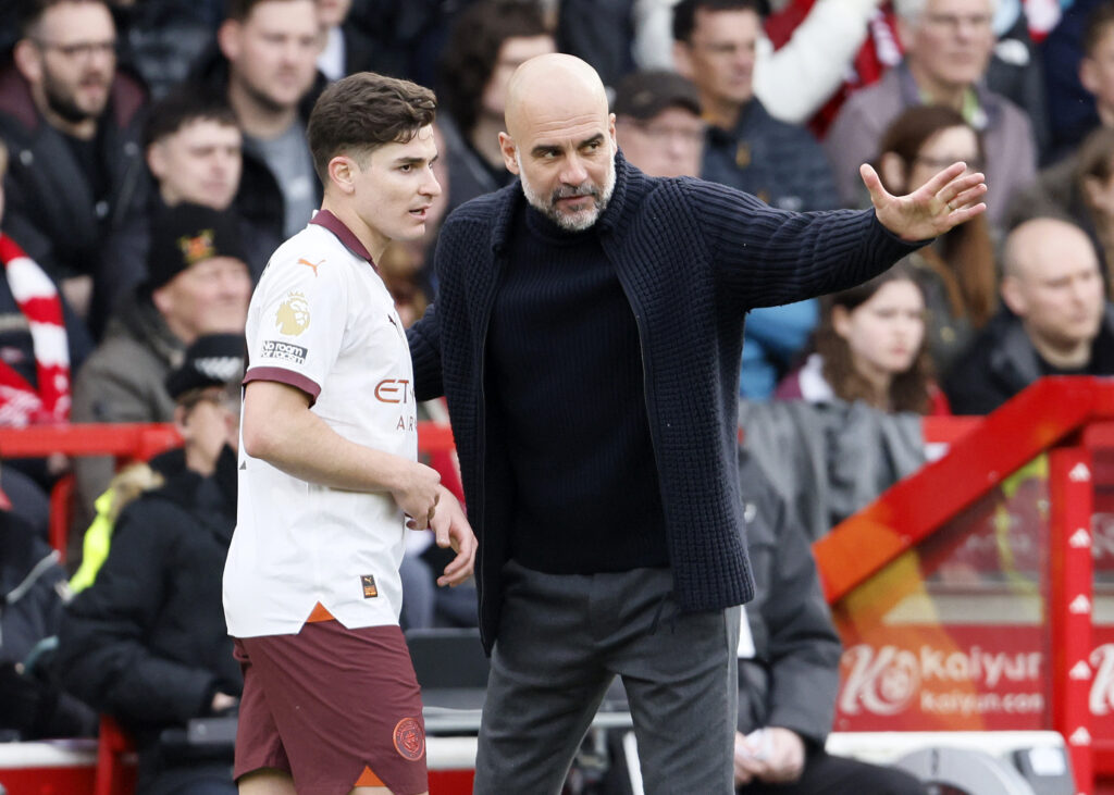 Pep Guardiola speaking to Julian Alvarez during a Manchester City game