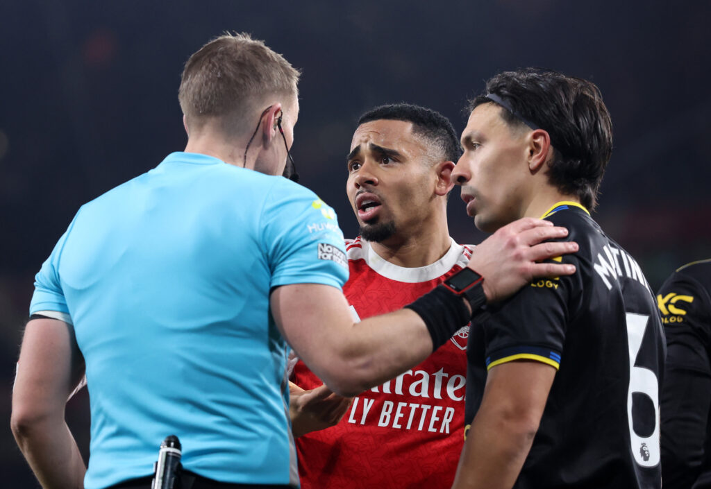 Referee Craig Pawson speaks to Gabriel Jesus and Lisandro Martinez after an incident during Arsenal vs Manchester United