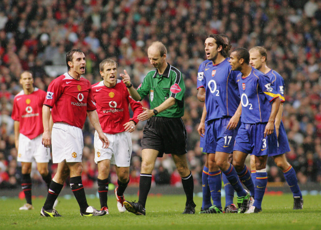 Manchester United and Arsenal players complain to referee Mike Riley during a game