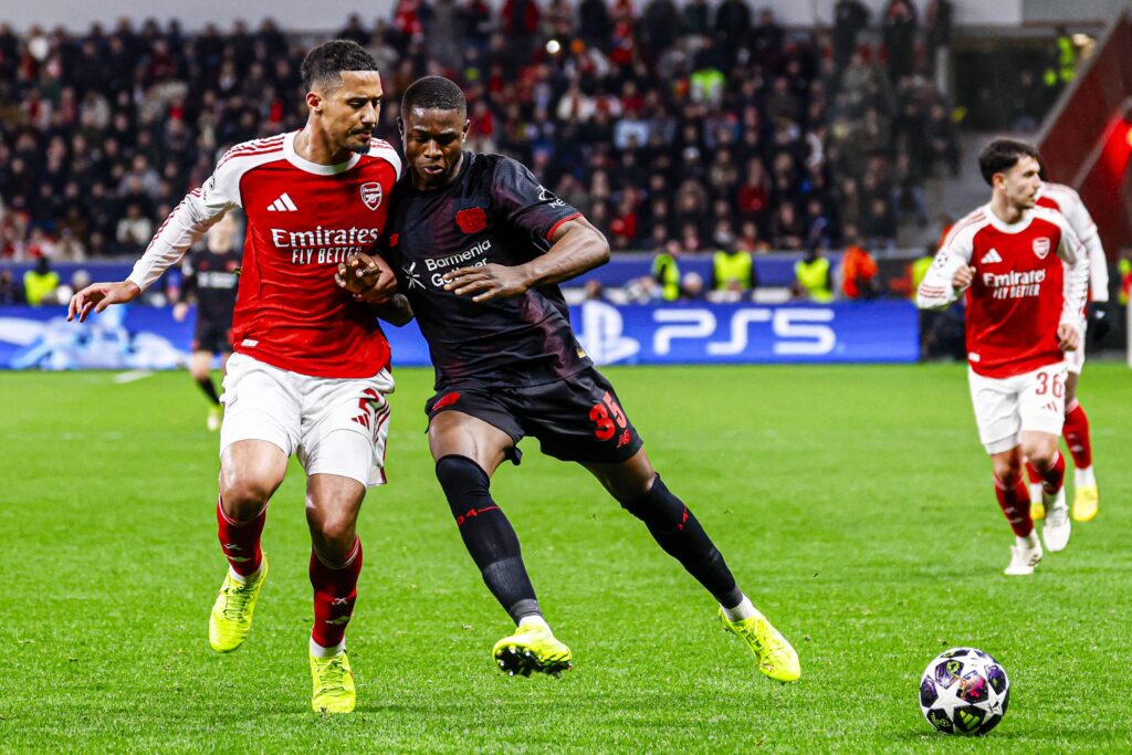 Christian Kofane challenges with William Saliba during a Champions League game between Arsenal and Bayer Leverkusen