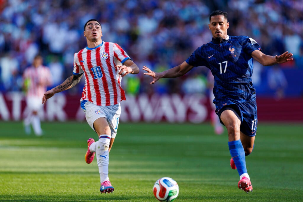 William Saliba beats Miguel Almiron in a race to win the ball during France vs Paraguay
